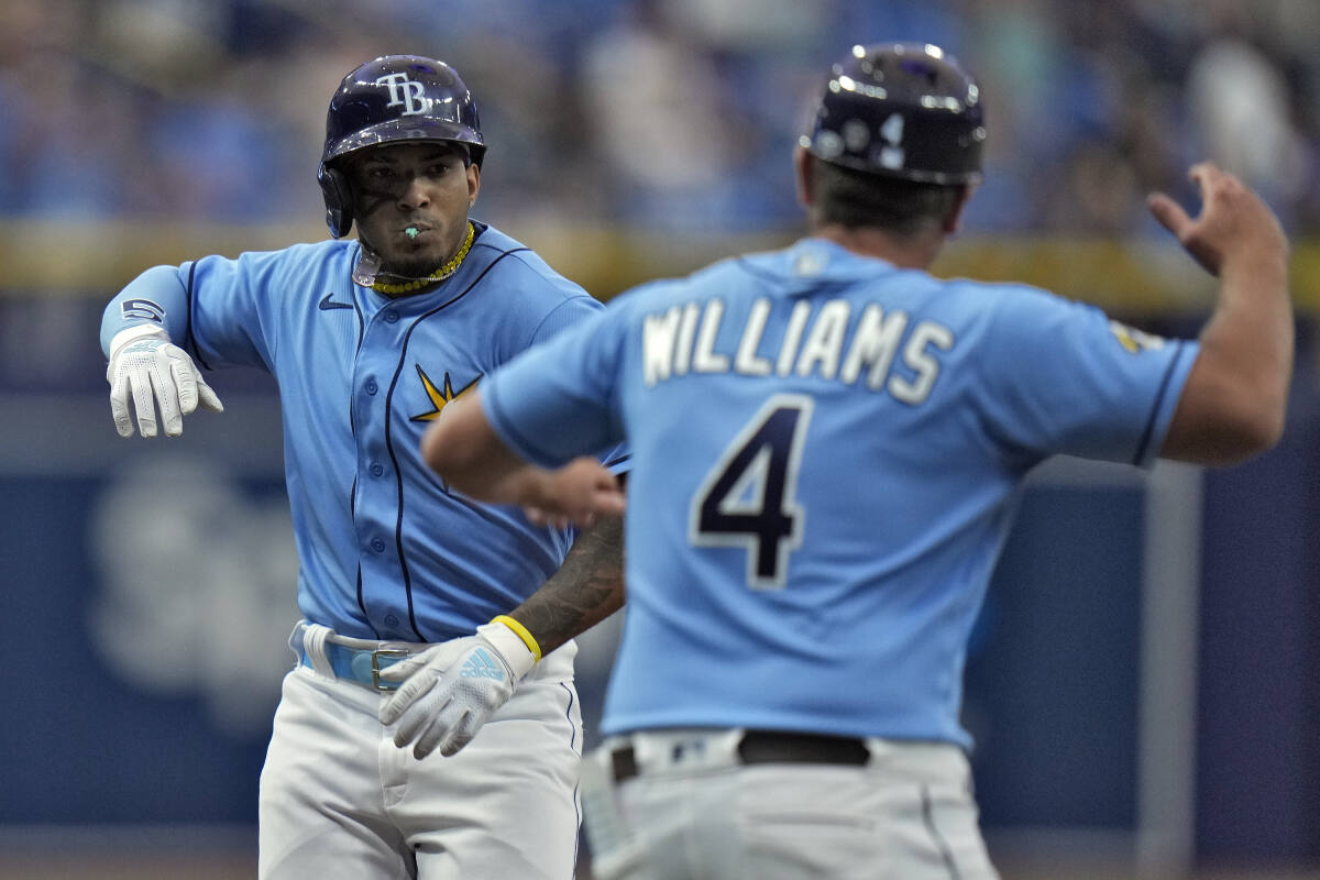 Tampa Bay Rays' Isaac Paredes, right, hits a two-RBI single during the  fourth inning of a baseball game as Oakland Athletics catcher Shea  Langeliers, left, watches Saturday, April 8, 2023, in St.