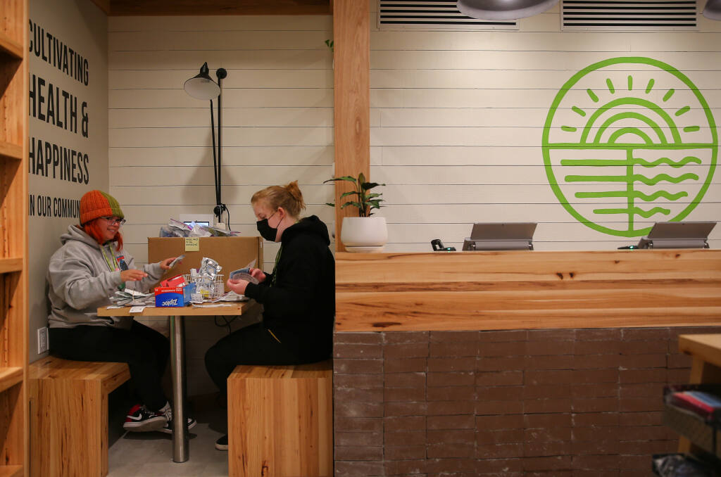Cynthia Curiel, left, and Emily Geiger sort products in the consultation area of the new Solful cannabis dispensary in Santa Rosa on Thursday, April 14, 2022. A provisional permit got the new dispensary open as it awaits its annual license.  (Christopher Chung/ The Press Democrat)