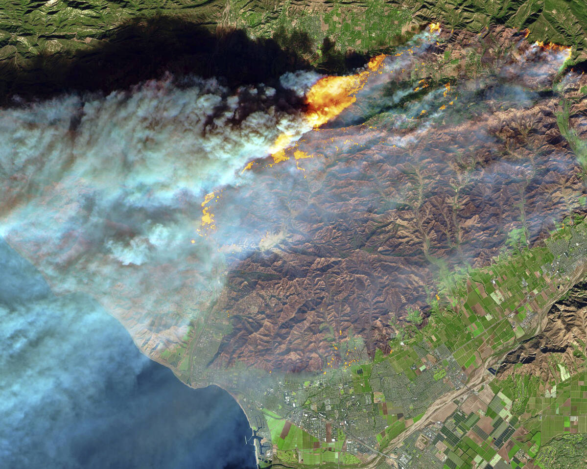 Thomas fire. This false-color image from the European Space Agency's Sentinel-2 satellite via NASA, shows the fire’s footprint north of the city of Ventura, at bottom center, on Dec. 7, 2017. (European Space Agency / NASA)