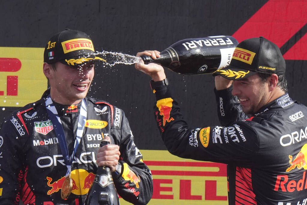 Max Verstappen drenched in champagne by teammate Sergio Perez.