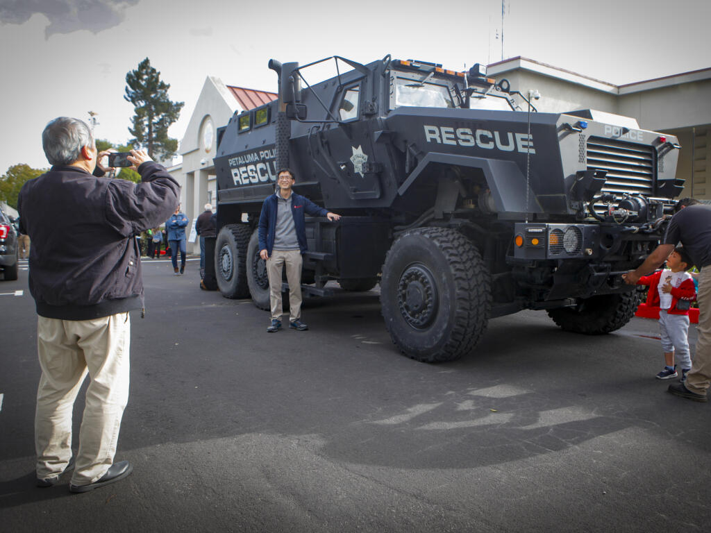 Gordon Wong takes a photo of his son Ryan in front of the Petaluma Police Department’s armored rescue vehicle, a military vehicle called an MRAP. The department displayed their armored vehicles for public viewing on Thursday, May 4, 2023. (CRISSY PASCUAL/ARGUS-COURIER STAFF)