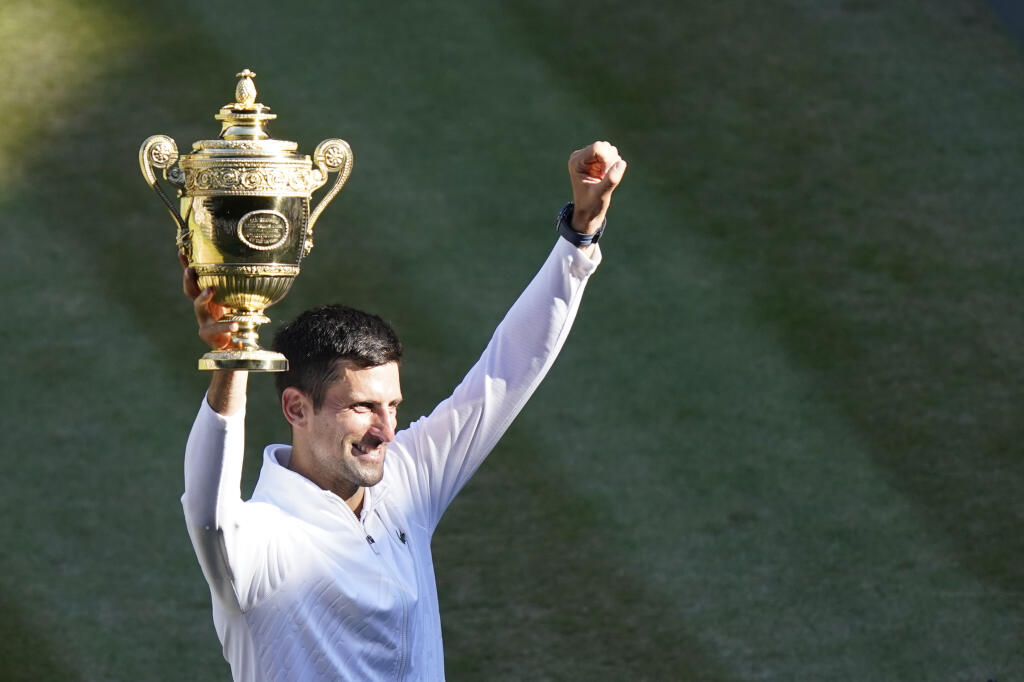 Serbia's Novak Djokovic holds the winners trophy as he celebrates after beating Australia's Nick Kyrgios to win the final of the men's singles on day fourteen of the Wimbledon tennis championships in London, Sunday, July 10, 2022. (AP Photo/Gerald Herbert)