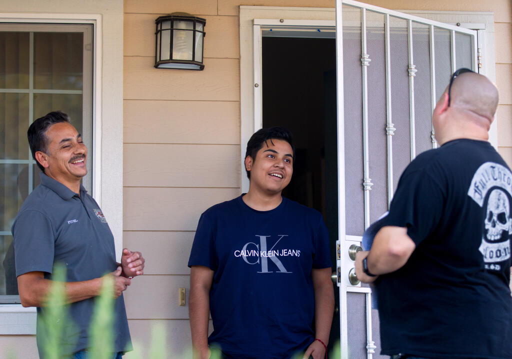 Josh Nultemeier, of Forestville, right, talks to Forestville resident Fidel Garcia and his son, Ivan Garcia, 20, about a petition to recall three West Sonoma County Union High School District board members on Thursday, July 29, 2021. (Darryl Bush / for The Press Democrat)