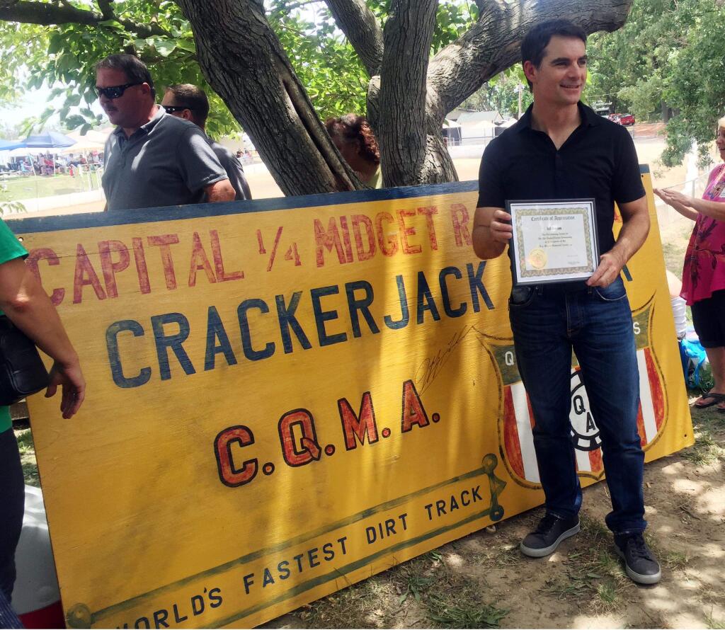 In this photo taken Saturday, June 20, 2015, NASCAR driver Jeff Gordon is presented with a certificate of appreciation for a financial donation he made several years ago to help keep the Roy Hayer Memorial Speedway open in Rio Linda, Calif. Gordon began his career at the quarter-midget dirt track when he was 5 and the track was called Crackerjack Track. (Jenna Fryer / Associated Press)