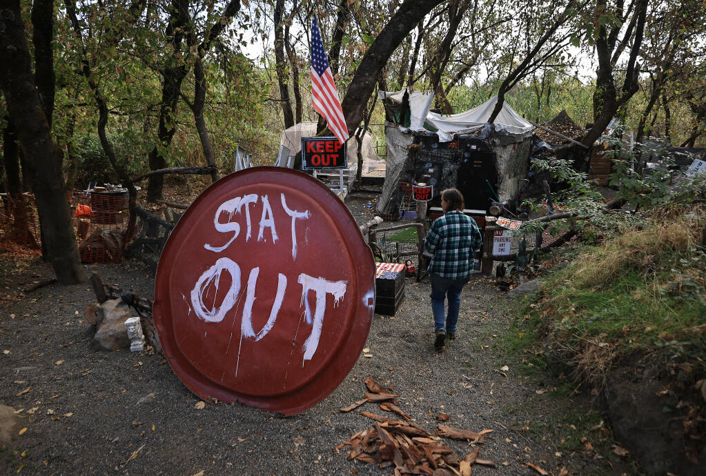 Carol Shumate of Russian Riverkeeper inspects an abandoned encampment along the Russian River, Thursday, Oct. 13, 2022, near Healdsburg. The encampment and many others, will have to come out due the location near a waterway, under new regulations adopted by county Board of Supervisors. (Kent Porter/The Press Democrat)