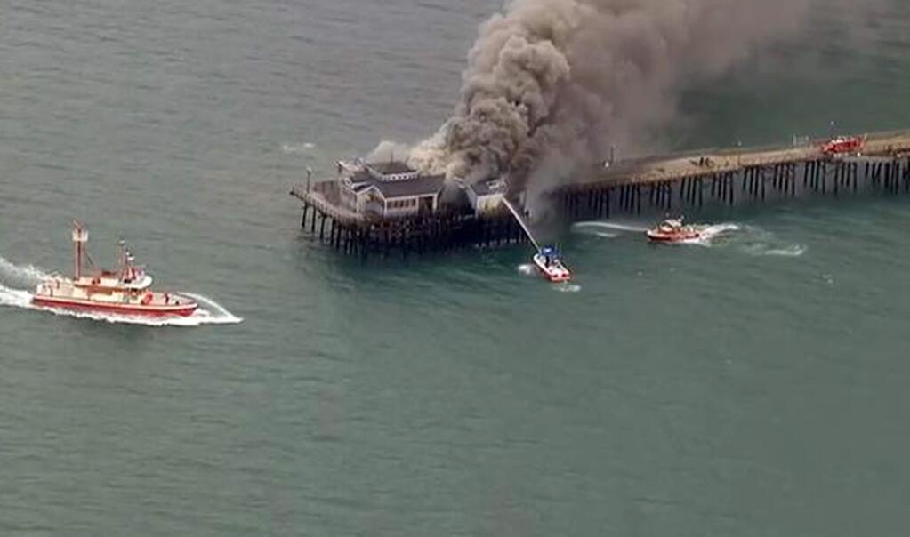 In this image made from video provided by KABC-TV, firefighters attack a fire on the Seal Beach pier in Seal Beach, Calif. on Friday, May 20, 2016. A fire is burning on a former restaurant on Southern California's Seal Beach Pier. The blaze erupted early Friday at the end of the long wooden pier southeast of Los Angeles. Harbor patrol boats are attacking the flames with streams from water cannons while firefighters direct streams from hoses on the pier. (KABC-TV via AP)