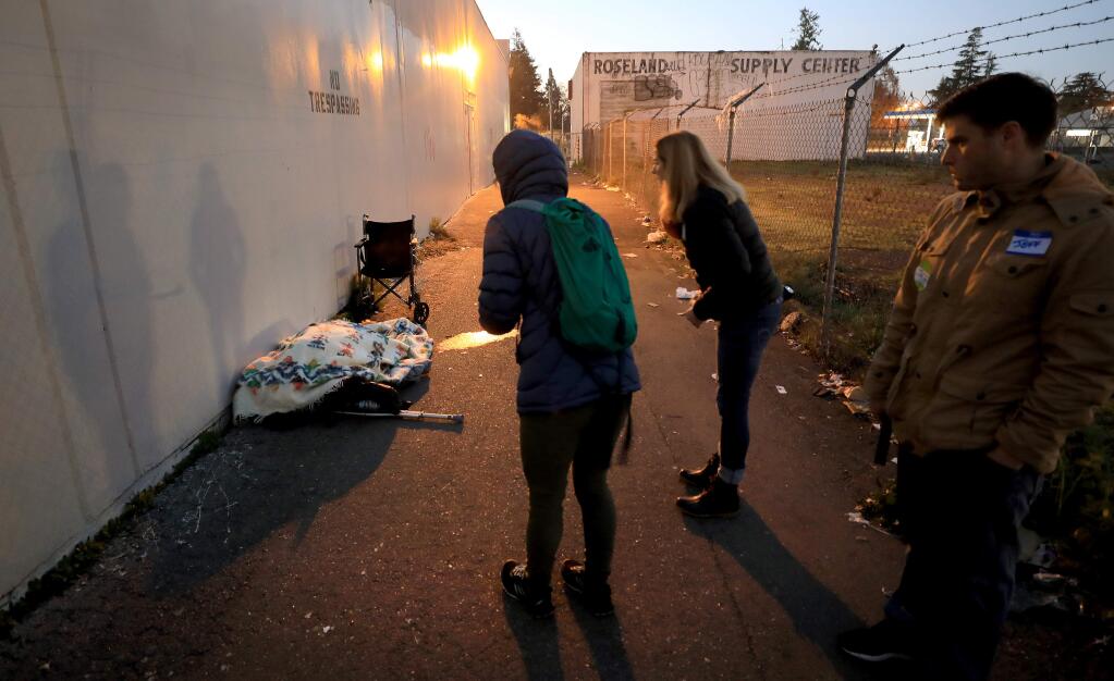 Behind Roseland Village in Santa Rosa, volunteers Kelli Kuykendall, Lisa Boehm, and Jeff Travers, right, attempt to identify the gender of a sleeping homeless individual during the 2019 Point-in-Time Homeless Count in Santa Rosa on Friday, Jan. 25, 2019. (KENT PORTER/ PD)