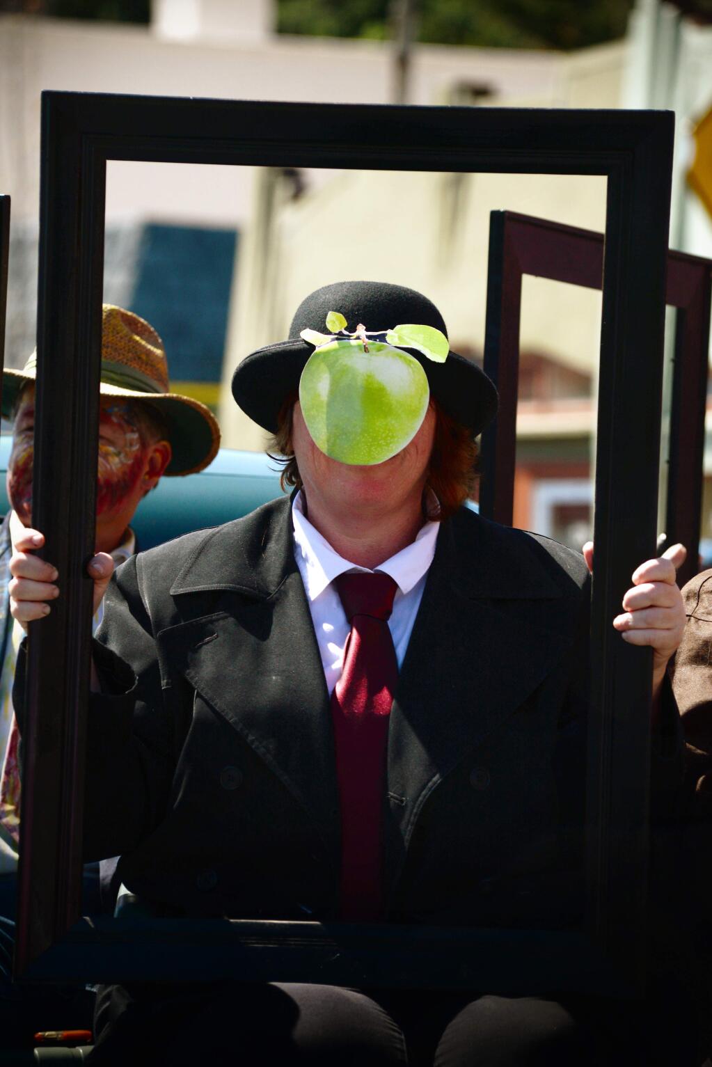 A woman poses as 'The Son of Man' by the Belgian surrealist painter René Magritte in a Studebaker for Art at the Source during the 70th annual Apple Blossom Parade held in Sebastopol Saturday. April 16, 2016. (Photo: Erik Castro/for The Press Democrat)