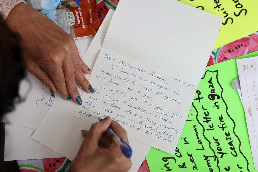 Elham Rafla-Yuan writes a letter to U.S. Rep. Jared Huffman during a pro-Palestinian rally at Old Courthouse Square in Santa Rosa, Sunday, Nov. 5, 2023. (Beth Schlanker / The Press Democrat)