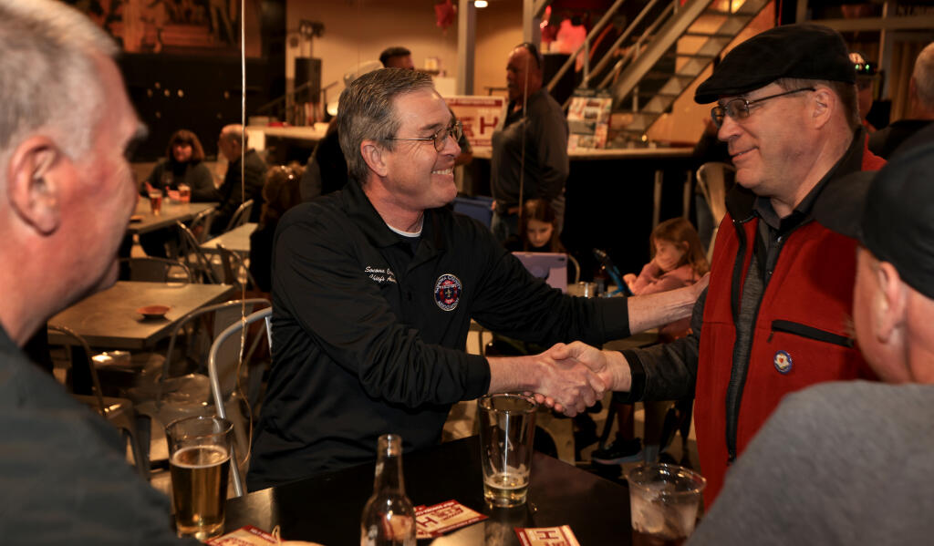 Steve Akre, Sonoma County Fire Chiefs Association President, middle, greets friends and co-workers at the Measure H election party at Coyote Sonoma, Tuesday, March 5, 2024 in Healdsburg. (Kent Porter / Press Democrat) 2024
