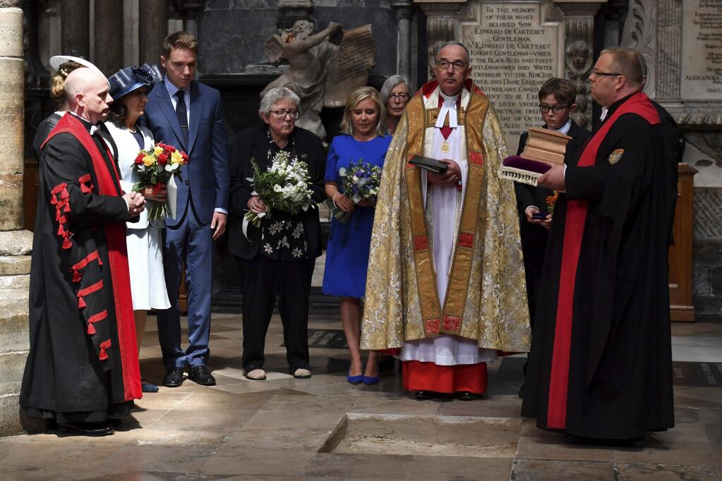 Dean of Westminster John Hall, centre right, accompanied by first wife Jane Hawking second left, and daughter Lucy Hawking, centre, presides over the internment of the ashes of scientist Professor Stephen Hawking during a memorial service in the nave at Westminster Abbey, in London, Friday June 15, 2018. Hawking will take his place among Britain's greatest scientists when his ashes are buried in Westminster Abbey, between the graves of Charles Darwin and Isaac Newton. (Ben Stansall/PA via AP)