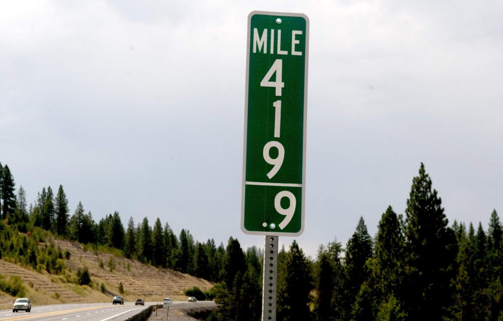 In this Tuesday, Aug. 11, 2015 photo, vehicles pass a 419.9 milepost just south of Coeur d'Alene, Idaho. Idaho joined Colorado in replacing milepost 420 signs with milepost 419.9 designations in an effort to thwart thievery. (Kathy Plonka/The Spokesman-Review via AP) COEUR D'ALENE PRESS OUT; MANDATORY CREDIT