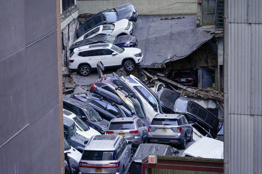 FILE — Cars are seen piled on top of each other at the scene of a partial collapse of a parking garage in the Financial District of New York, April 18, 2023, in New York. After the deadly collapse of a parking structure in lower Manhattan, New York City building officials swept through dozens of parking garages and ordered four of them to immediately shutter because of structural issues that "deteriorated to the point where they were now posing an immediate threat to public safety." (AP Photo/Mary Altaffer, File)