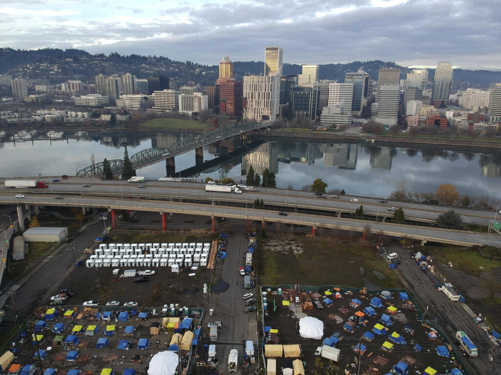 A large homeless encampment along the Willamette River near downtown Portland, Oregon. The city conducted a sweep of downtown camps in May. (CRAIG MITCHELLDYER / Associated Press)