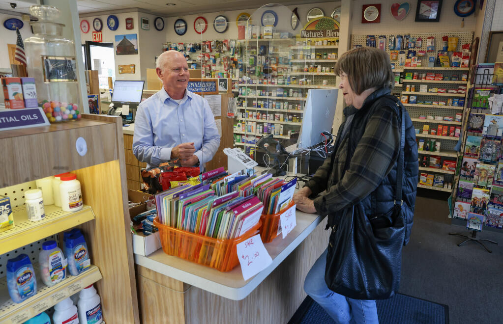 Pharmacist Mike McCaskill, left, talks with customer Lana Ward at the Tuttle’s Pharmacy location on Hoen Avenue in Santa Rosa, Monday, Jan. 29, 2024.  McCaskill has worked at the Tuttle’s Pharmacy location for 25 years. (Christopher Chung / The Press Democrat)