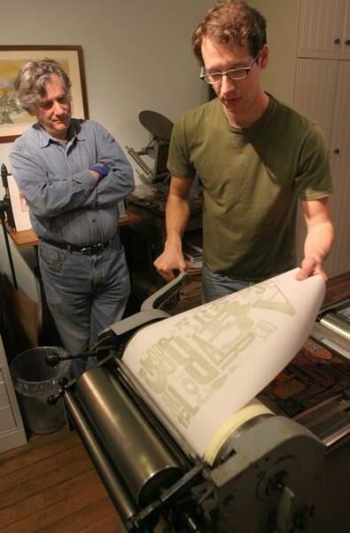 David Keller (cq) watches Nathan Rose (cq) pulls a print off of the old-fashioned letterpress printer during an intro to letterpress wrapping paper class taught by rose at Dauphine Press on Kentucky Street in Petaluma on Thursday night May 11, 2006.