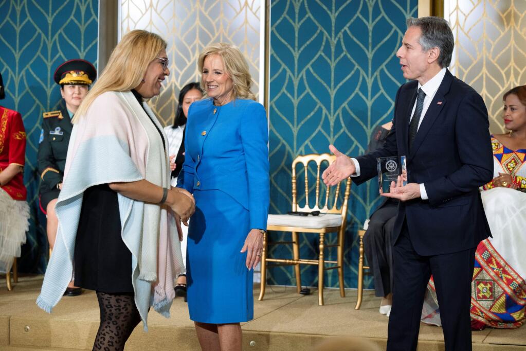 Alba Rueda, of Argentina, receives the International Women of Courage Award from Secretary of State Antony Blinken with first lady Jill Biden, during a ceremony in the East Room of the White House, in Washington, to commemorate International Women's Day, Wednesday, March 8, 2023. (AP Photo/Manuel Balce Ceneta)