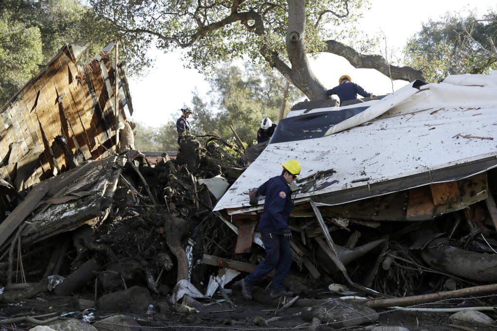 FILE - Search and rescue personnel scan a home in the aftermath of a mudslide, Jan. 13, 2018, in Montecito, Calif. Experts say California has learned important lessons from the Montecito tragedy, and the state has more tools to pinpoint the hot spots and more basins and nets are in place to capture the falling debris before it hits homes. (AP Photo/Marcio Jose Sanchez, File)