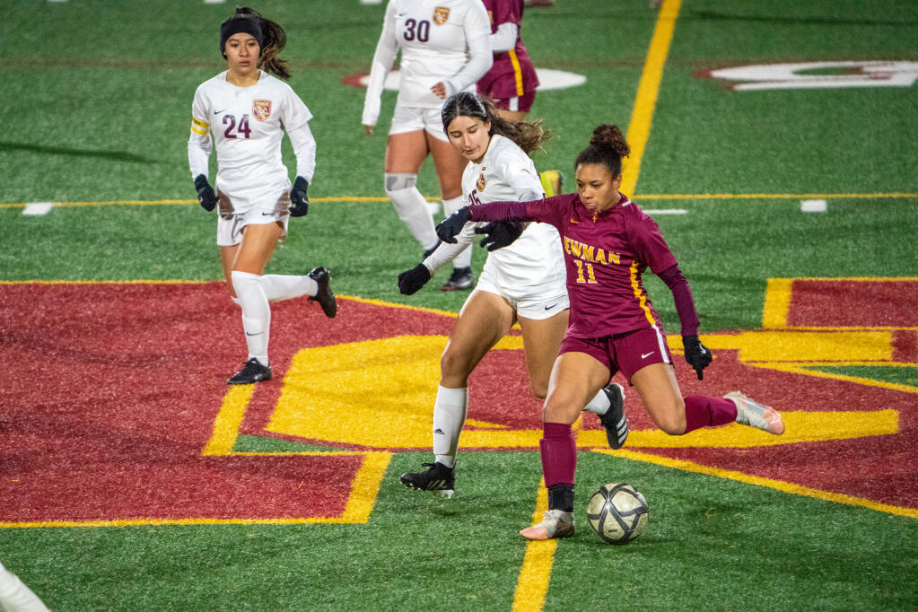 Cardinal Newman’s Abella Hunter, right, attempts to outrun Piner’s Yanely Tejada during their game Tuesday, Feb. 14, 2023 in Santa Rosa. (Nicholas Vides / For The Press Democrat)