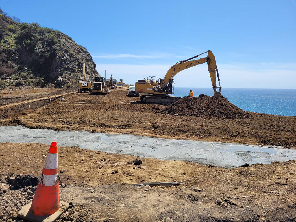 This April 5, 2021 photo provided by the California Department of Transportation shows a Caltrans construction crew working on repairing a section of Highway 1 along the Pacific Ocean in Big Sur, Calif., that was washed away during a winter storm on January 28, 2021. Highway 1 along Big Sur is expected to reopen by April 30, 2021, because work to repair a huge piece of roadway that crumbled during a storm is nearly two months ahead of schedule, the California Department of Transportation announced Thursday, April 8, 2021. (Caltrans District 5 via AP)
