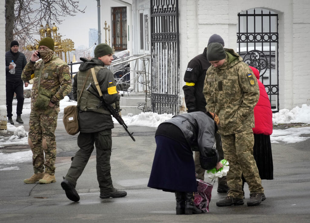 Ukraine's secret service examine belonging of a parishioner at the entrance to the Pechersk Lavra monastic complex in Kyiv, Ukraine, Tuesday, Nov. 22, 2022. Ukraine's counter-intelligence service, police officers and the country's National Guard searched one of the most famous Orthodox Christian sites in the capital, Kyiv, after a priest spoke favorably about Russia – Ukraine's invader – during a service. (AP Photo/Efrem Lukatsky)