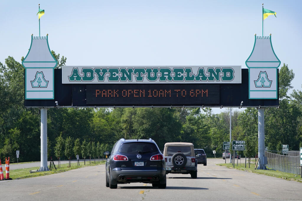Visitors arrive at the Adventureland Park amusement park, Tuesday, July 6, 2021, in Altoona, Iowa.  (AP Photo/Charlie Neibergall)