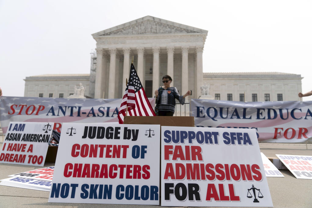 A person protests outside of the Supreme Court in Washington, Thursday, June 29, 2023. The Supreme Court on Thursday struck down affirmative action in college admissions, declaring race cannot be a factor and forcing institutions of higher education to look for new ways to achieve diverse student bodies. (AP Photo/Jose Luis Magana)