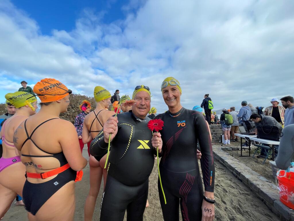 Theresa Drew, right, and friend Duncan McCallum, left, of Santa Rosa prepare to toss a flower in the bay to mark the start of the Swim Across America San Francisco Bay Open Water Swim Saturday, Sept. 30, 2023. Drew swims in memory of her son David, who died in 2011 at aged 10. McCallum swims in honor of Allyson Allgower who died in 2022 of brain cancer. (Theresa Drew)