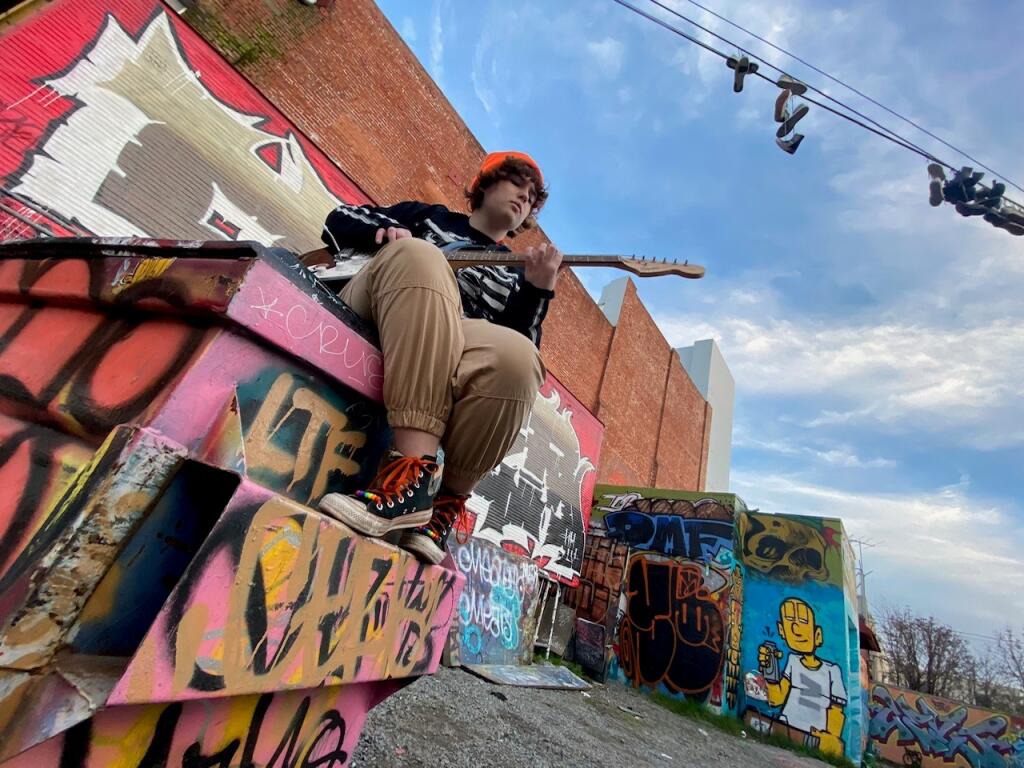 M.J. Ward poses atop a dumpster behind the Phoenix Theater in Petaluma, where he’ll perform this month. (James Ward)