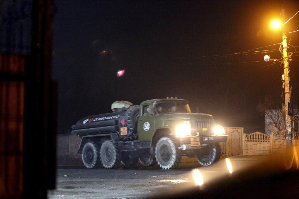 A military truck drives down a street outside Donetsk, the territory controlled by pro-Russian militants, eastern Ukraine, late Tuesday, Feb. 22, 2022. Russian President Vladimir Putin has raised the stakes in the Ukraine standoff by recognizing the independence of rebel regions in the country's east. A key question now is whether he will stop at that or try to move deeper into Ukraine. (AP Photo)