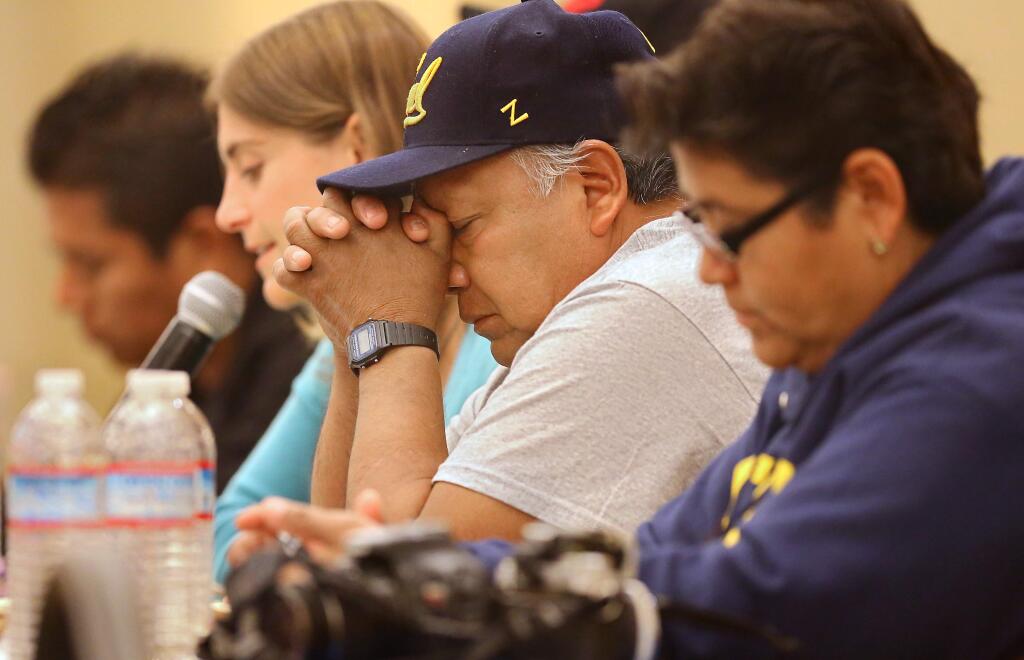Estanislao Mendoza Chocolate bows his head while a translator, Emily Pederson, relays his speech about his son and the missing 43 Rural Teachers' College of Ayotzinapa students, during a Caravana 43 public forum at Sonoma State University, in Rohnert Park on Tuesday, April 7, 2015. (Christopher Chung/ The Press Democrat)