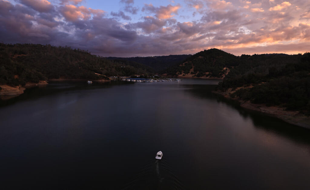 Sunset paints the sky as a boater heads to the private marina on the Warm Springs Creek arm at Lake Sonoma, Saturday, Sept. 2, 2023. (Kent Porter / The Press Democrat)