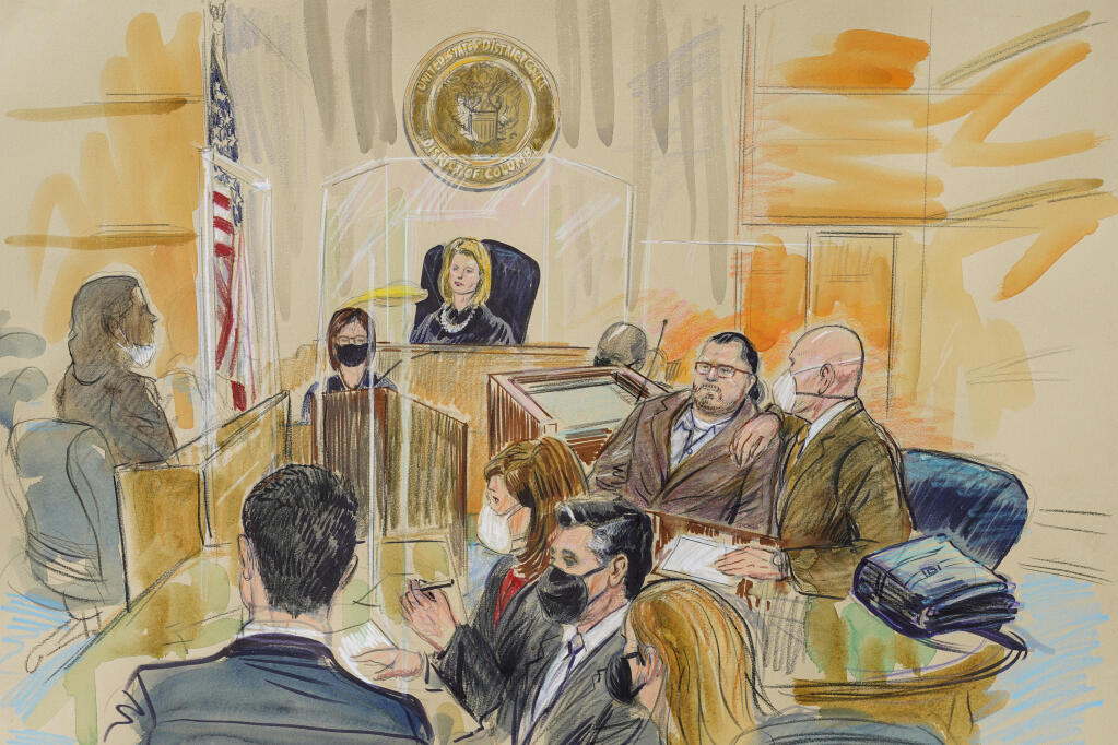 This artist sketch depicts Judge Dabney Friedrich looking out from the bench during jury selection for Guy Wesley Reffitt, joined by his lawyer William Welch, top right, in Federal Court, in Washington, Monday, Feb. 28, 2022. Seated from front left are members of the U.S. prosecution legal team, Tim Ryan, Risa Berkower, Jeff Nestler, and Amanda Rohde. Reffitt, a Texas man charged with storming the U.S. Capitol with a holstered handgun on his waist, is the first Jan. 6 defendant to go on trial. (Dana Verkouteren via AP)