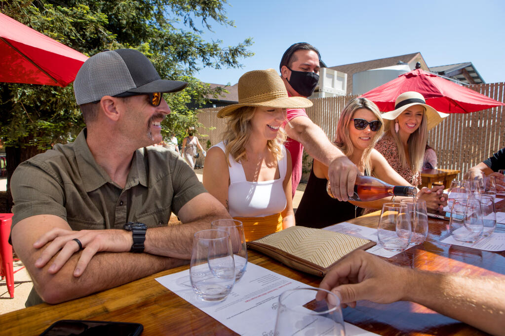 Left to right,Travis Eagan and wife, Katie Eagan, both of Chico, await wine poured by Hook and Ladder's Devin Ruddick, with friends watching, Danielle Atlas, of Butte Valley, Calif., and Jamie Markey of Chico, in background. (Photo by Darryl Bush / For The Press Democrat)