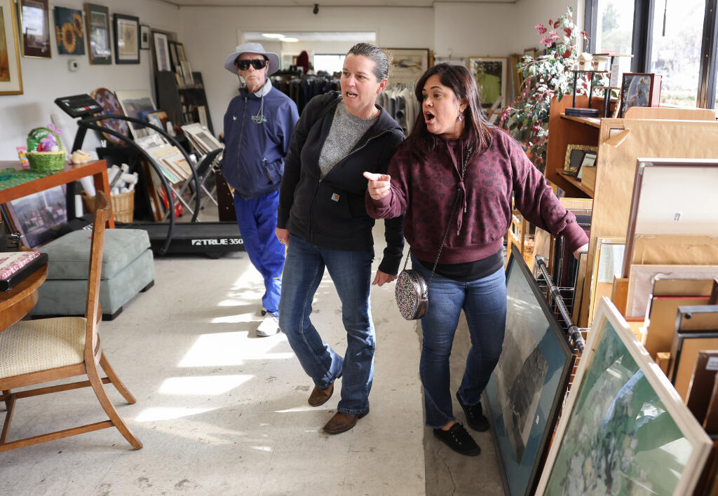 Alyce Hernandez, left, and Mishel Schweikl spot a painting they like while shopping at Pick of the Litter thrift store in Santa Rosa, Thursday, Feb. 16, 2023. (Christopher Chung/The Press Democrat)