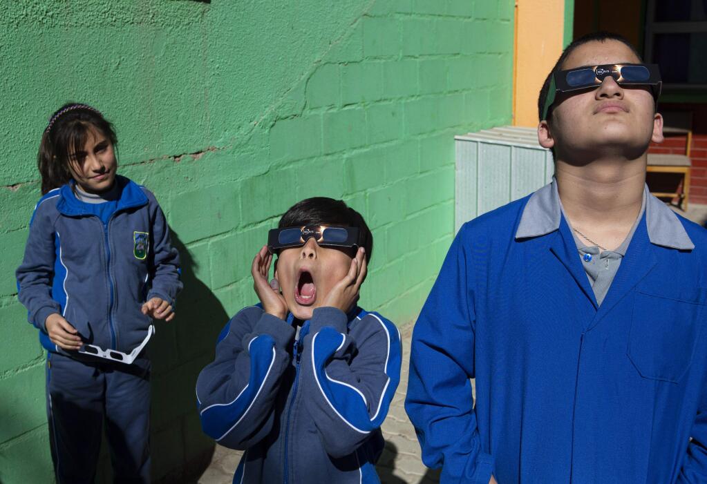 A student reacts as he tries on the special glasses he'll use to view tomorrow's total solar eclipse at Pedro Pablo Munoz school in La Higuera, Chile, Monday, July 1, 2019. Tourists and scientists will gather in northern Chile, one of the best places in the world to watch the next the eclipse that will plunge parts of South America into darkness. (AP Photo/Esteban Felix)