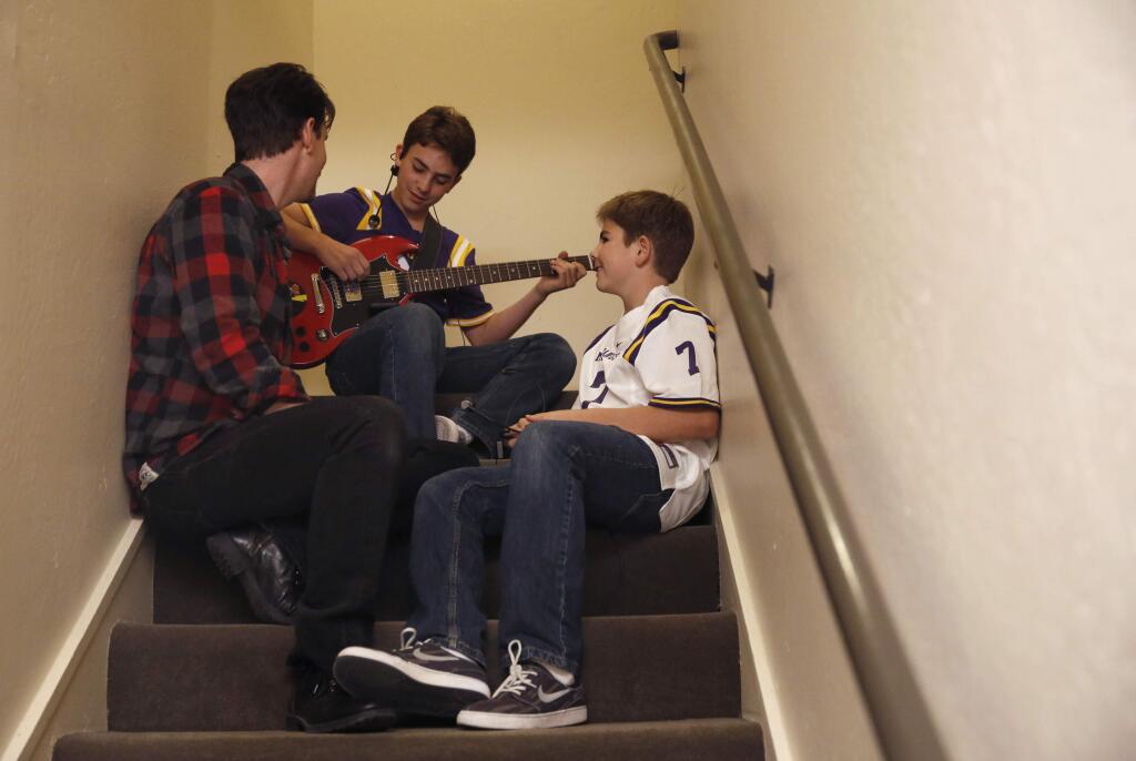 Twin brothers, Vittorio, rear, and Vincenzo Piazza, 12, of the band V2 sit backstage with their base guitarist and teacher Cameron Peterson during the 'Putting Out the Fire' concert at the Wells Fargo Center for the Arts on Sunday, November 15, 2015 in Santa Rosa. (BETH SCHLANKER/ The Press Democrat)
