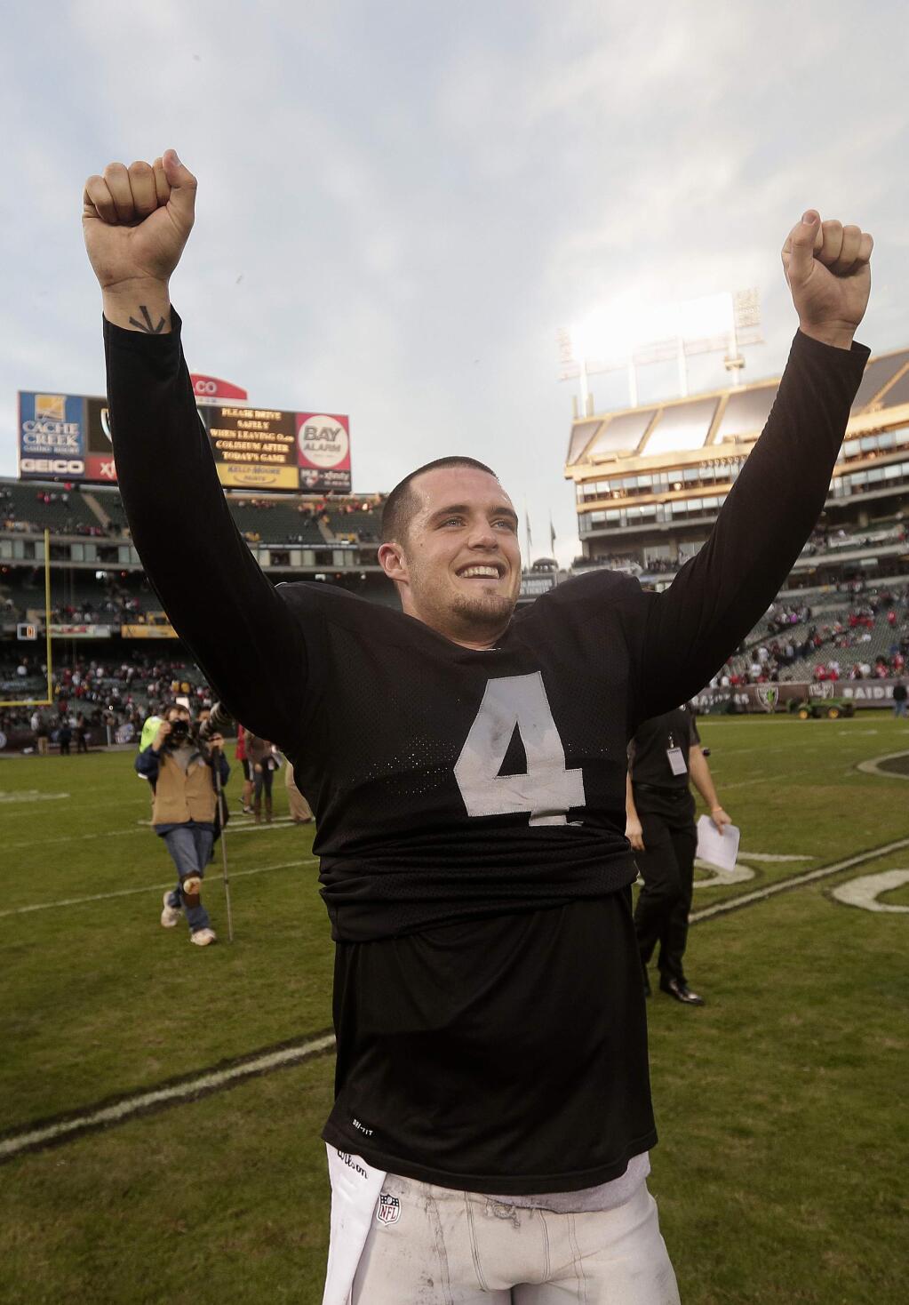 Oakland Raiders quarterback Derek Carr (4) celebrates after the Raiders defeated the San Francisco 49ers in an NFL football game in Oakland, Calif., Sunday, Dec. 7, 2014. The Raiders won 24-13. (AP Photo/Marcio Jose Sanchez)
