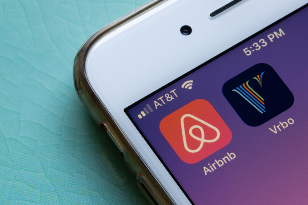 Airbnb and Vrbo mobile app icons are seen on an iPhone. The companies are competitors in online vacation rental business concept.