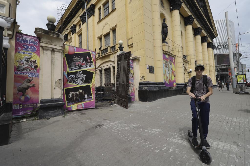 A man rides his scooter past an area where a Wagner Group military company's tank was parked near the headquarters of the Southern Military District in Rostov-on-Don, southern Russia, Sunday, June 25, 2023. After a deal was reached Saturday, mercenary chief Yevgeny Prigozhin ordered his troops to halt their march on Moscow and retreat to field camps in Ukraine, where they have been fighting alongside Russian troops. (AP Photo)