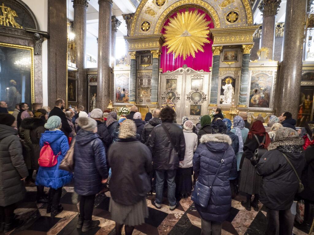 Orthodox believers gather for Sunday's prayer in the Kazansky Cathedral in St.Petersburg, Russia, Sunday, March 29, 2020. The leader of the Russian Orthodox Church is calling on believers to stay away from churches during the coronavirus pandemic and to pray at home instead. The new coronavirus causes mild or moderate symptoms for most people, but for some, especially older adults and people with existing health problems, it can cause more severe illness or death. (AP Photo/Dmitri Lovetsky)