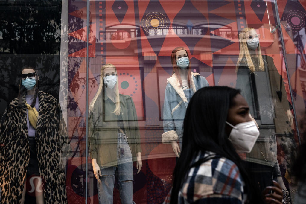 A shopper walks past mannequins donning face masks in Los Angeles in 2020. California's COVID-19 emergency declaration ended on Feb. 28, 2023, but there's been a recent uptick in cases across the state. Photo by Jae C. Hong, AP Photo