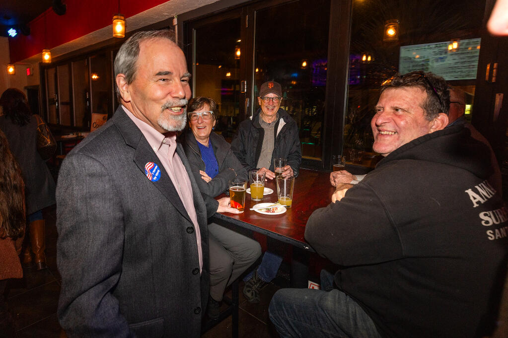 Sonoma County Supervisor Chris Coursey, left, talks with supporters at his election night party at the Barrel Proof Lounge Tuesday, March 5, 2024 in Santa Rosa. (Photo by John Burgess/The Press Democrat)