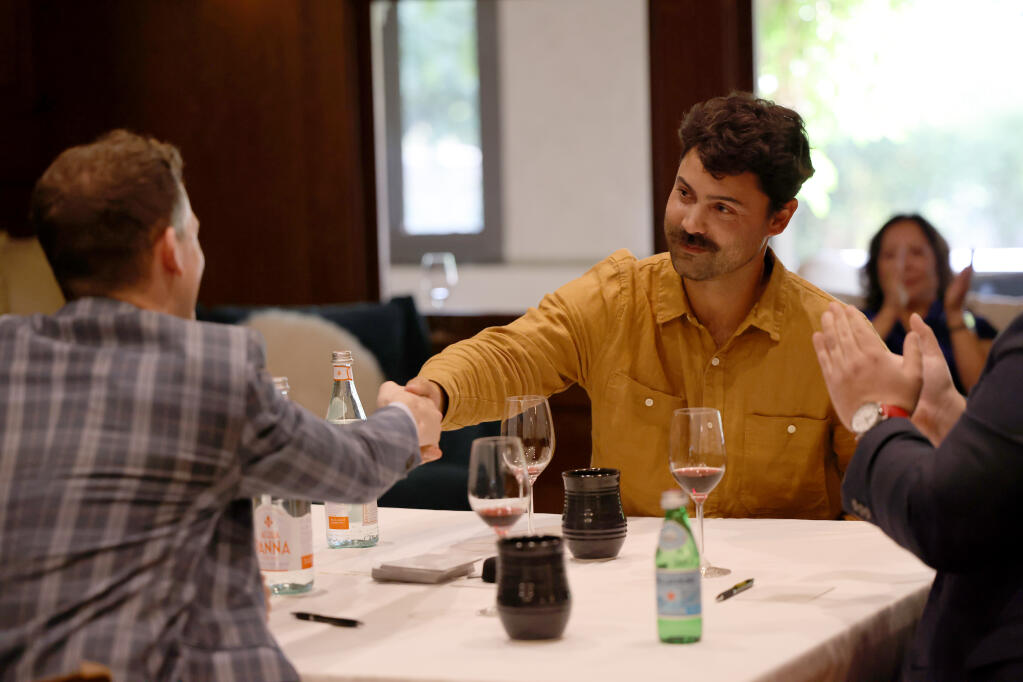 Nick Meidinger shakes his opponents hand after a round during a Wine Rival wine tasting competition at a private event space in Rutherford, Sunday, July 23, 2023. (Beth Schlanker / The Press Democrat)