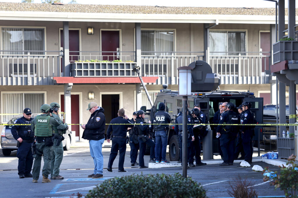 Petaluma and Santa Rosa police and SWAT team members gather in the parking lot of the Best Western Petaluma Inn during an incident with an armed suspect in Petaluma, Tuesday, March 12, 2024. (Beth Schlanker / The Press Democrat)
