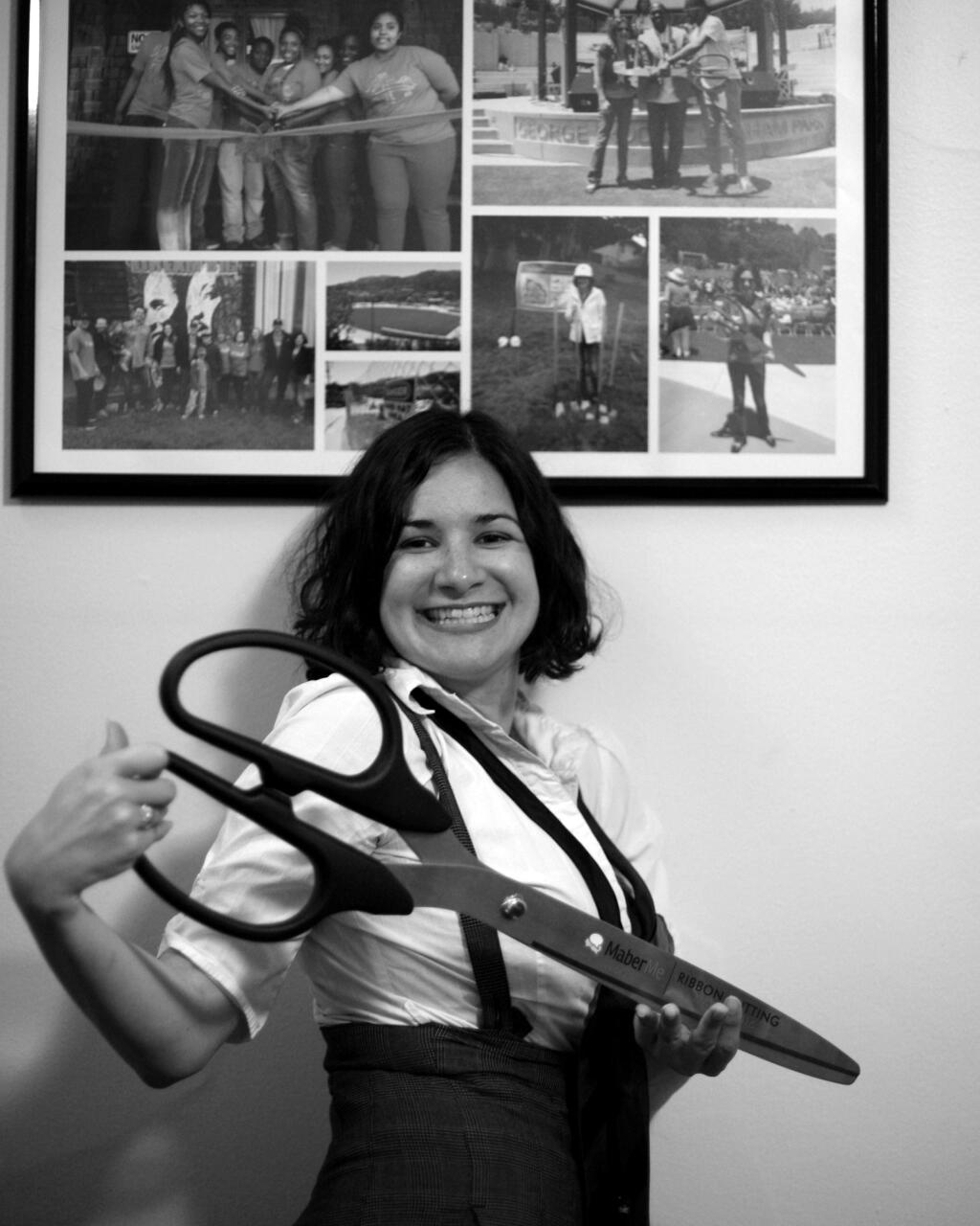 Domenica Giovannini: At the ribbon-cutting of her downtown office, the Petaluma-based marketing professional poses with a collection of photos of ribbon cuttings at various parks and teen centers she helped to make happen.(PHOTO BY TYREE BUSH)