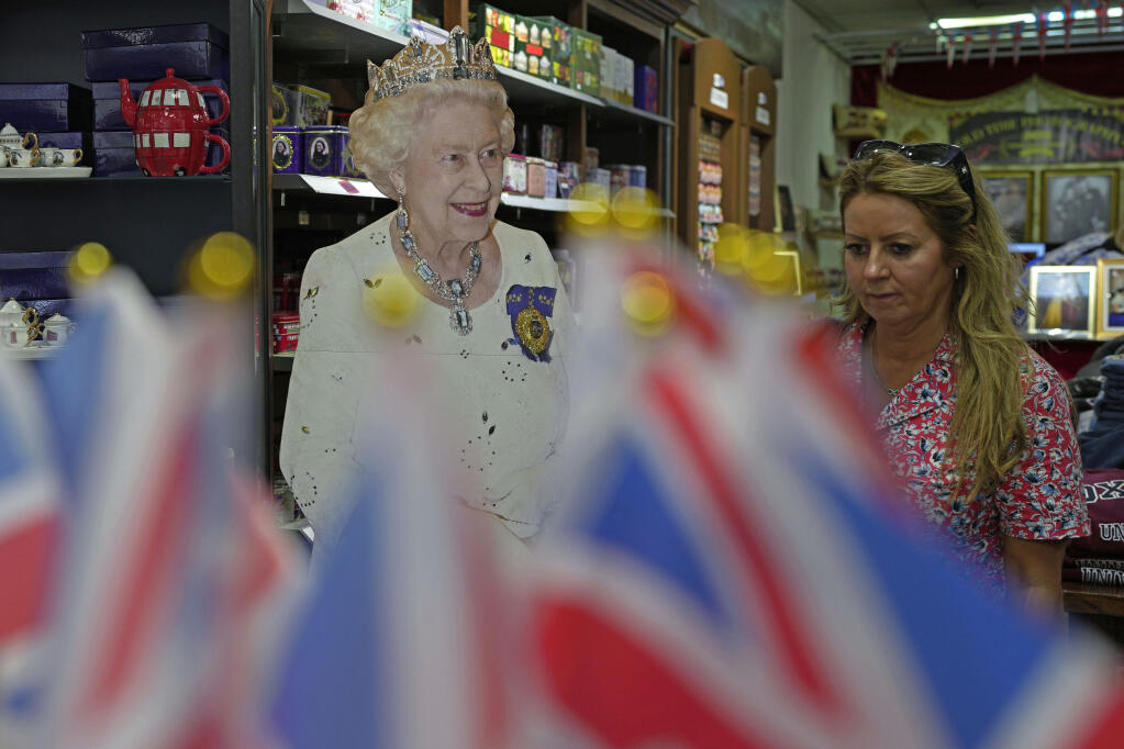A customer walks in a gift shop in London, Monday, Sept. 12, 2022. Just days after the death of Queen Elizabeth II, unofficial souvenirs have rolled out at royal-themed gift shops in London and online marketplaces like Amazon and Etsy. (AP Photo/Kin Cheung)