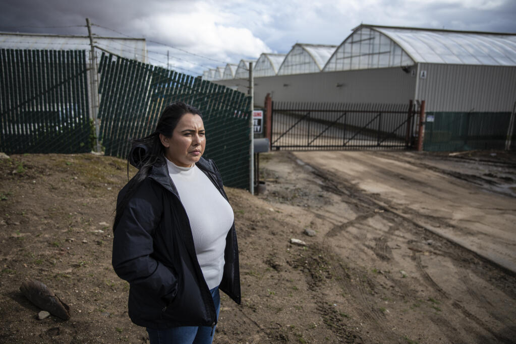 Michelle Hackett at the entrance to Riverview Farms in Salinas that flooded in the mid-March storms. Photo by Martin do Nascimento, CalMatters