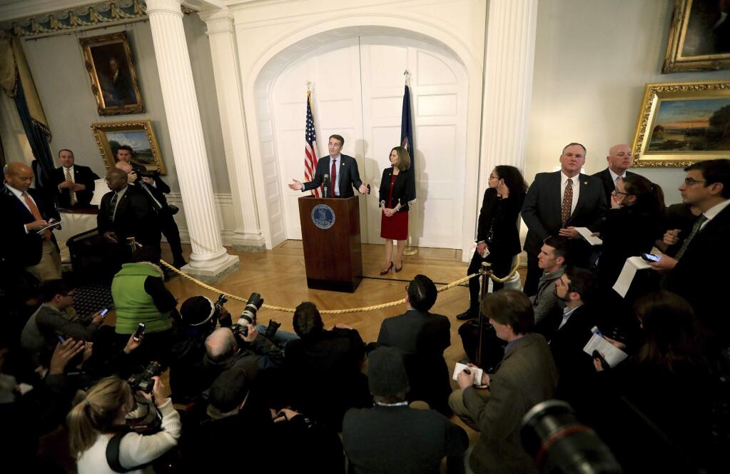 Virginia Gov. Ralph Northam, with his wife Pam at his side, speaks at a press conference in the Executive Mansion at the Capitol in Richmond, Va., Saturday, Feb. 2, 2019. Northam is under fire for a racial photo that appeared in his college yearbook. (Steve Earley/The Virginian-Pilot via AP)