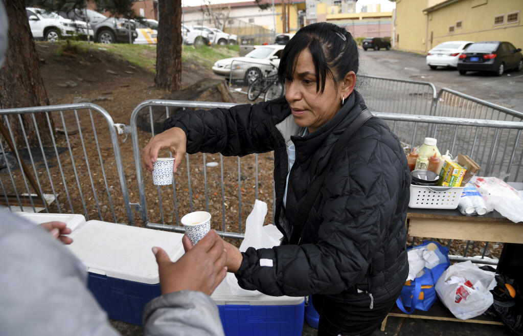 Yesenia Montero sells home-cooked Venezuelan-style food to fellow Venezuelan migrants sheltering at a motel designated for migrants in Denver, Colorado, Thursday, April 18, 2024. Montero said she traveled to Denver four months prior after hearing the city offered migrants housing and food, after spending four days in Washington D.C. (AP Photo/Thomas Peipert)